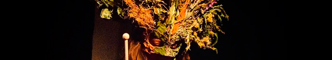 Persona de cabello largo con una máscara de plantas secas