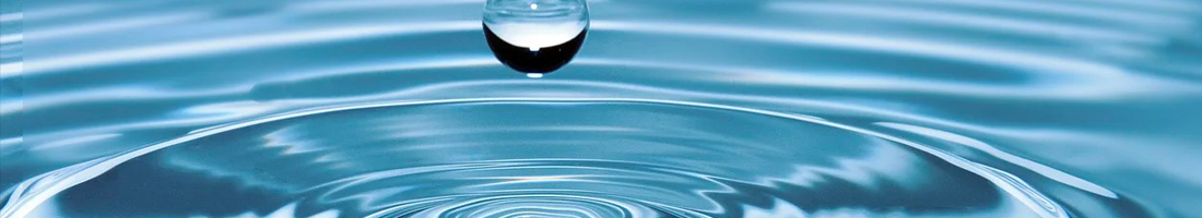 Gota de agua generando una onda en el agua.