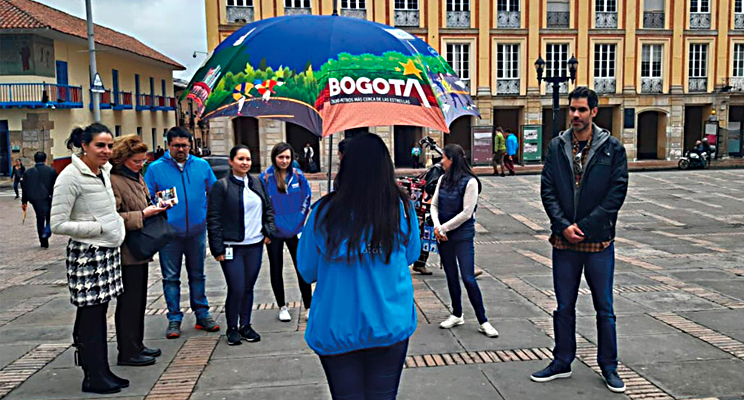 Fotografía de un grupo de personas tomando un tour guiado por funcionarios del IDT en el centro e Bogotá.