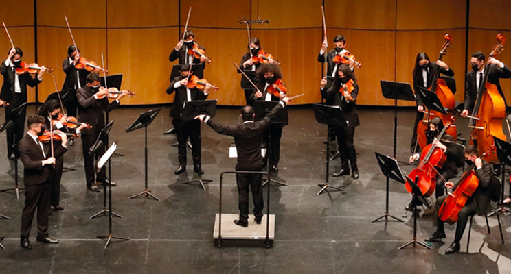 Fotografía de una orquesta juvenil interpretando los instrumentos