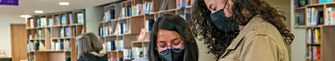 Foto de dos mujeres leyendo en la biblioteca