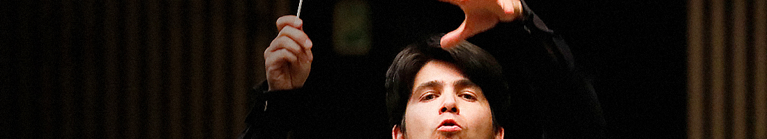 Fragmento de una fotografía en donde se encuentra la cara de un director de orquesta gestualizando con su rostro y sus manos en torno en virtud a la dirección de sus músicos