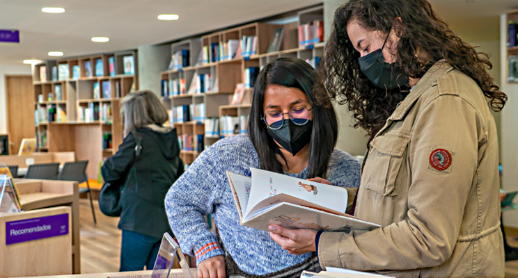 Foto de dos mujeres leyendo en la biblioteca