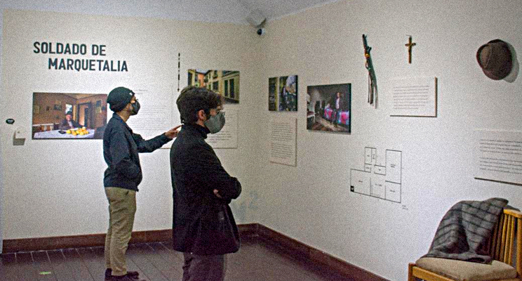 Ciudadanos apreciando una exposición sobre el soldado de Marquetalia