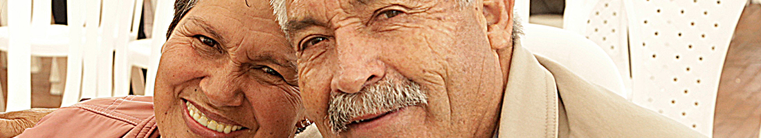 Fotografía de dos personas de la tercera edad, hombre y mujer compartiendo juntos y sonriendo