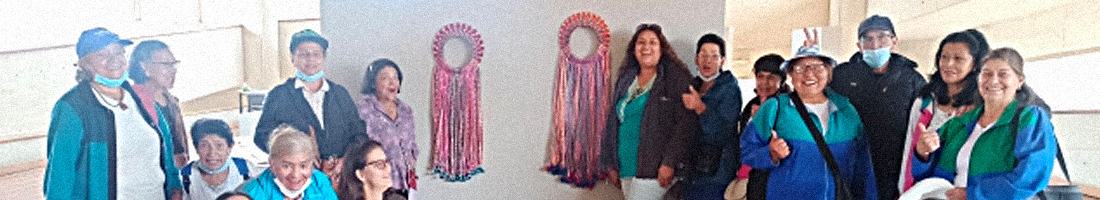 Fotografía de señoras de la tercera edad posando para la foto acompañadas de una escultura