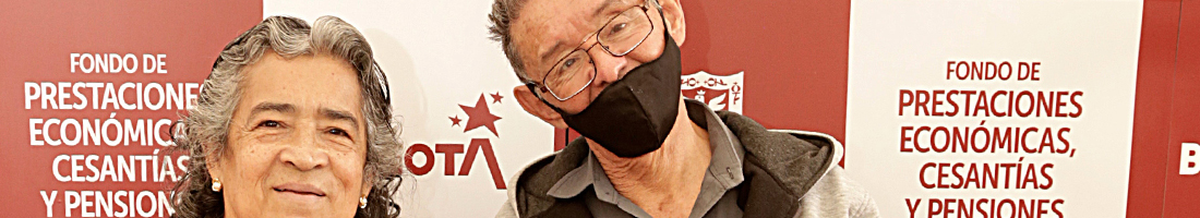 En la foto dos adultos mayores sonriendo ante la cámara