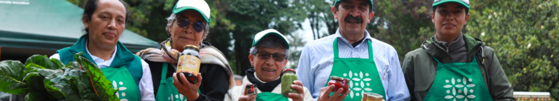 En la foto cinco adultos sonriendo y promocionando sus productos