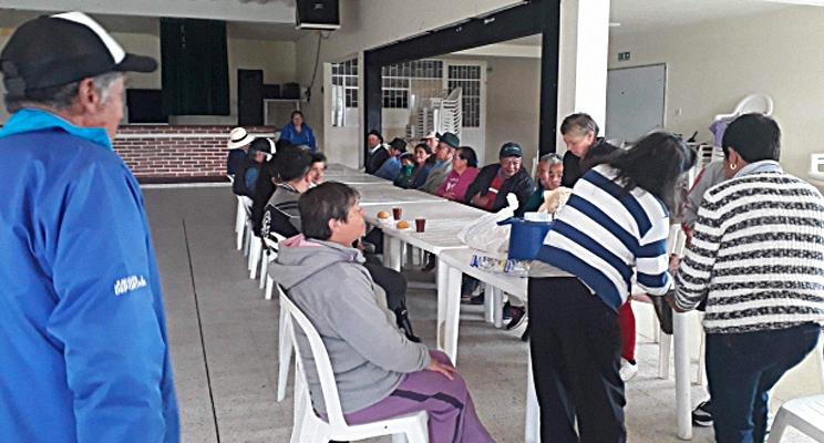 Foto panorámica donde se aprecias personas de la tercera edad en una dinámica en la biblioteca.