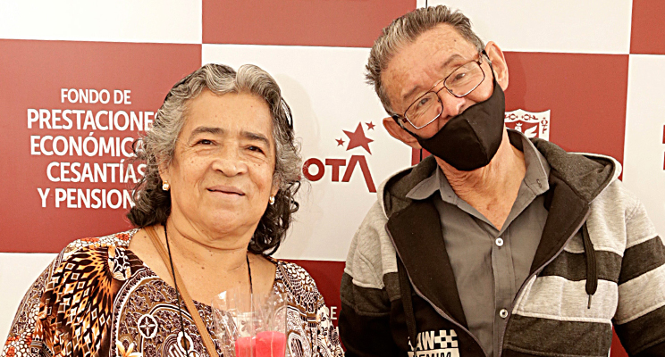 En la foto dos adultos mayores sonriendo ante la cámara