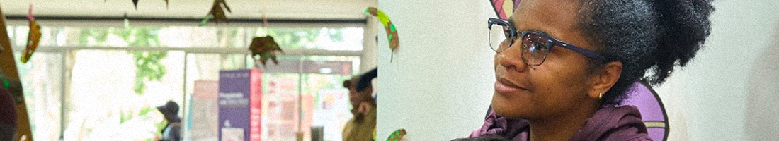 En la foto una mujer afro con gafas apreciando algo con mucha atención