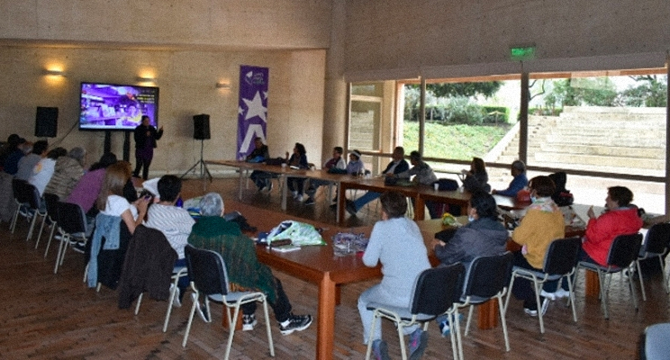 Un grupo de adultos mayores reunidos en la biblioteca.