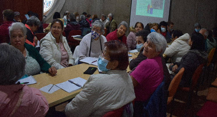 Grupo de adultas mayores en la biblioteca charlando.