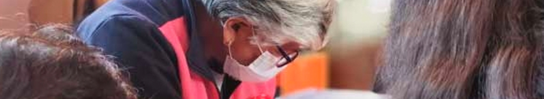 Señora de la tercera edad con gafas mirando hacia abajo en el taller