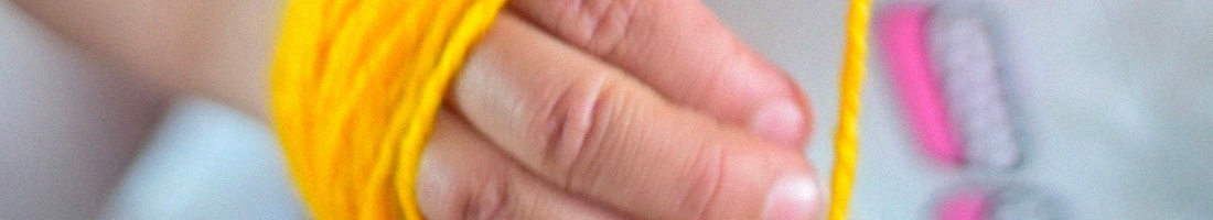 Mano pequeña con lana amarilla