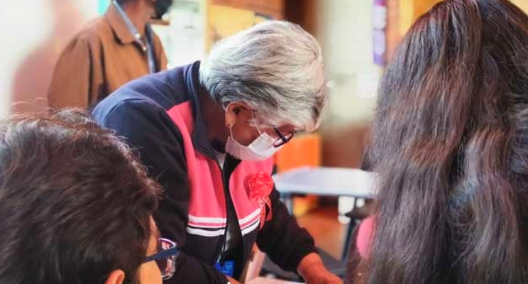Señora de la tercera edad con gafas mirando hacia abajo en el taller