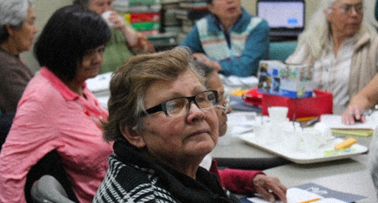 Señoras de la tercera edad con gafas prestando atención en el espacio de taller