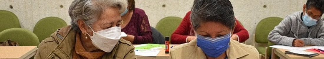 Señoras de la tercera edad realizando actividades en espacio de taller en la biblioteca