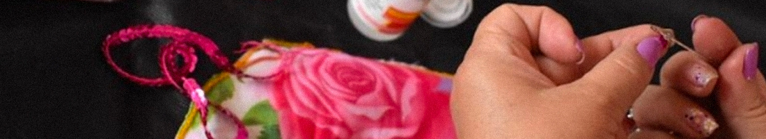 Manos de una mujer hilando una aguja