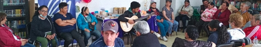 Grupo de adultos mayores en el espacio de taller en la biblioteca.