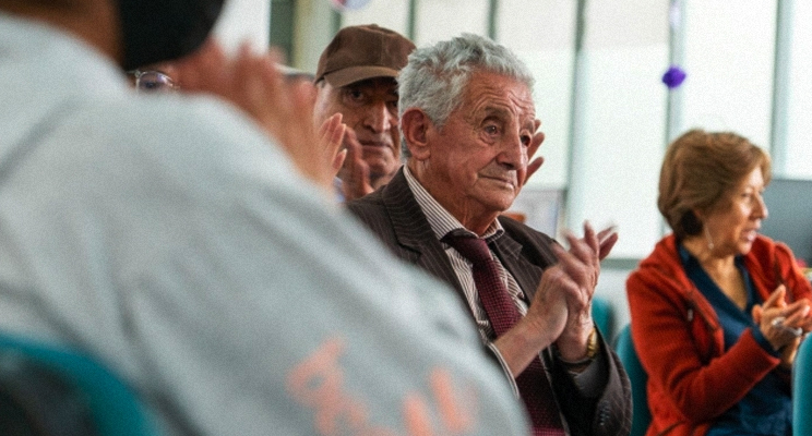 Adultos mayores aplaudiendo y participando de la actividad de taller