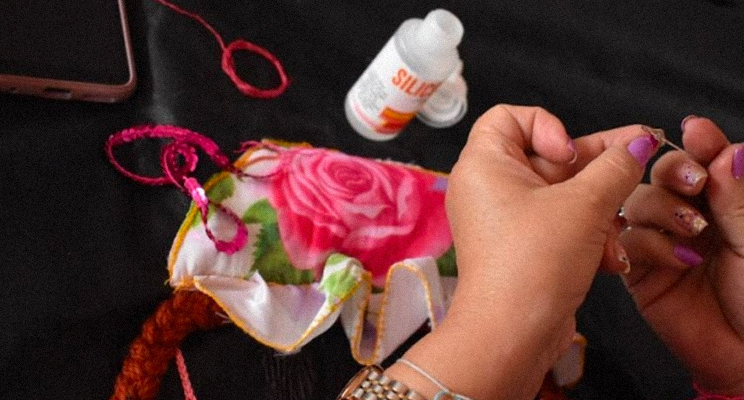 Manos de una mujer hilando una aguja