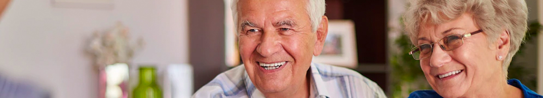 Dos adultos mayores (Mujer y Hombre) sonriendo 