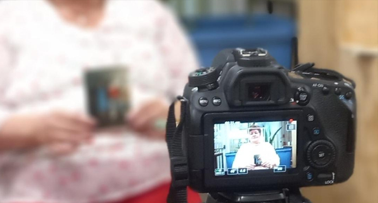 Señora de la tercera edad frente a una cámara grabando un testimonio.