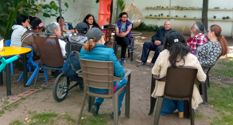 Grupo de adultos mayores charlando entre si.