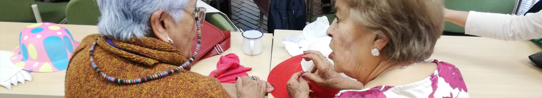 Dos adultas mayores conversando y participando del espacio de taller