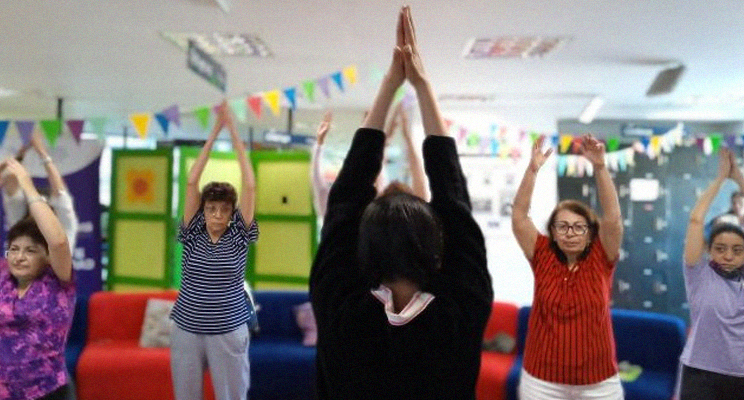 Adultas mayores realizando yoga en la biblioteca