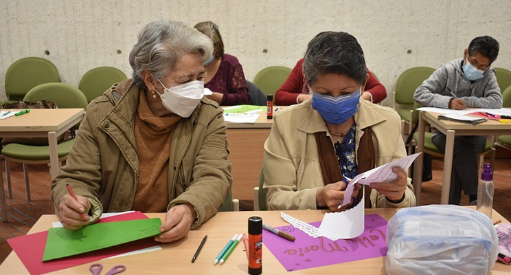 Dos mujeres adultas mayores charlando en el espacio de taller en la biblioteca