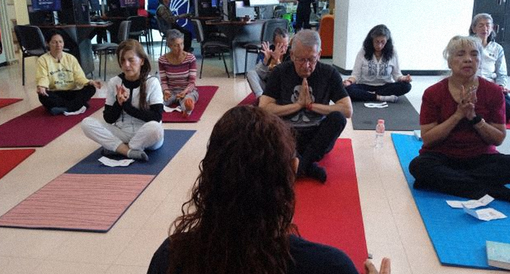 Personas mayores haciendo yoga en la biblioteca