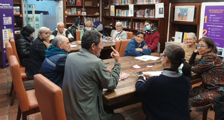 Personas mayores charlando en el espacio de taller en la biblioteca