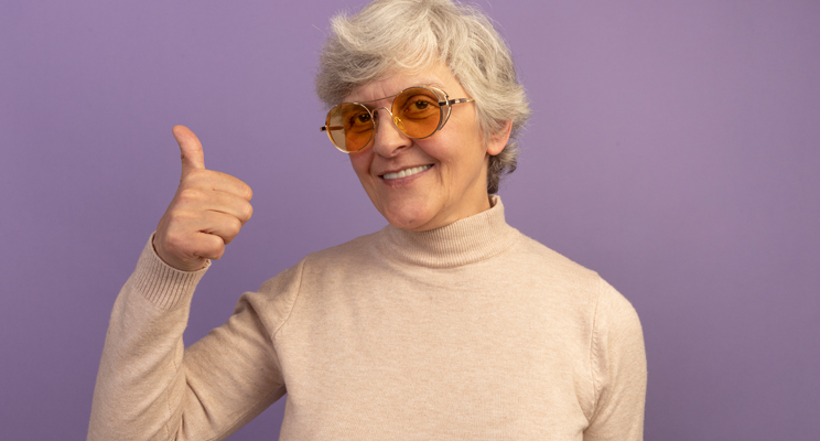 Anciana sonriente vistiendo un su茅ter de cuello alto