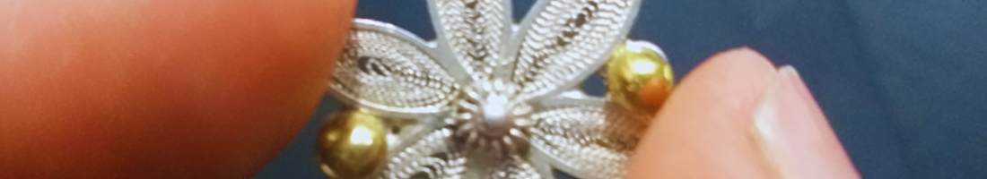 imagen de mano sosteniendo flor hecha en filigrana