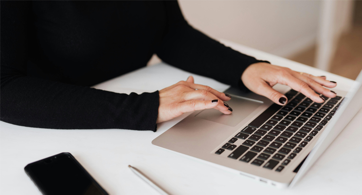 mujer escribiendo en un computador