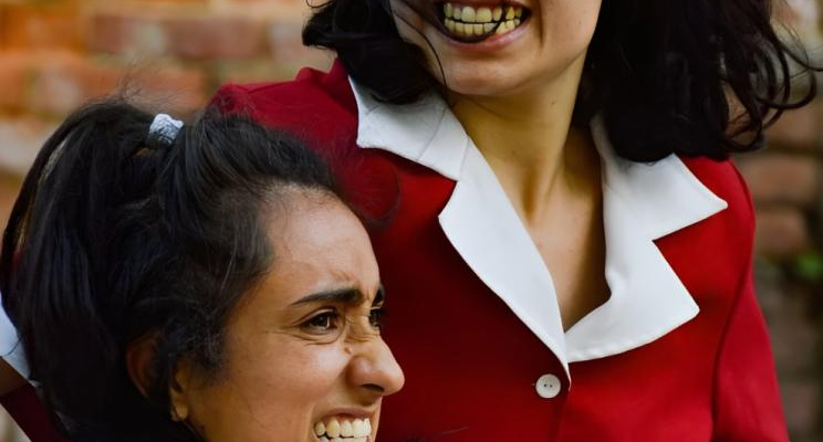 Dos mujeres reunidas vestidas de rojo