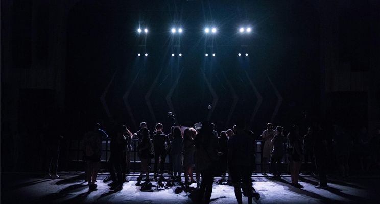 Personas ubicadas en tarima de teatro
