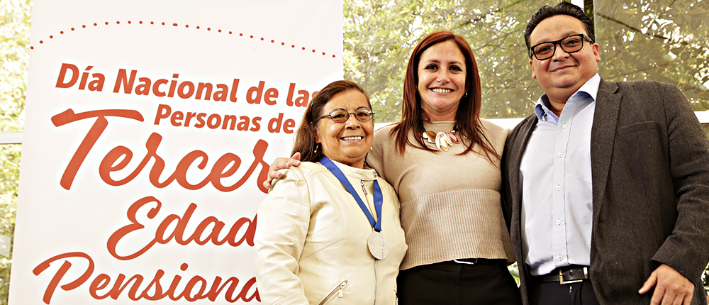 Una de nuestras pensionadas galardonadas en compañía de nuestra directora y subdirector jurídico al momento de recibir la medalla.