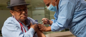 En la foto apreciamos a Don Carlos Julio Chaparro pensionado del FONCEP, al cual le están aplicando una vacuna por parte de Carlos Solórzano, colaborador de la Secretaría Distrital de Salud. - Foto: FONCEP