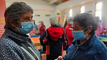 Fotografía de dos señoras de la tercera edad compartiendo en una actividad de BibloRed.
