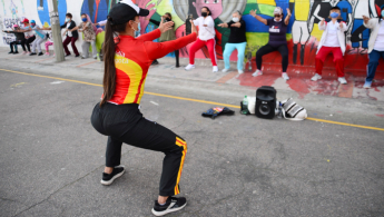 Grupo de personas realizando ejercicios en un parque guiados por una experta del IDRD