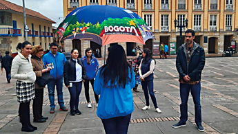 Fotografía de un grupo de personas tomando un tour guiado por funcionarios del IDT en el centro e Bogotá.