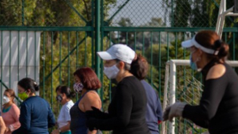 Fotografía de personas realizando ejercicio en un parque distrital, guiados por un colaborador del IDRD.
