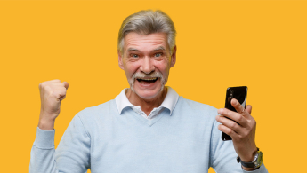Fotografía primer plano del rostro de un señor de la tercera edad muy sonriente, sobre un fondo de color amarillo.