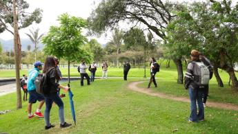 Fotografía de un grupo de caminantes en un parque distrital guiados un una colaboradora del IDRD