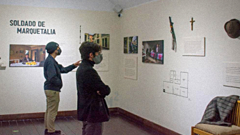 Ciudadanos apreciando una exposición sobre el soldado de Marquetalia
