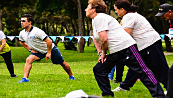 Grupo de adultos mayores realizando ejercicio en el parque.