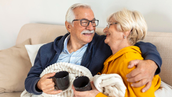 Fotografía de una pareja de la tercera edad mirándose a lo ojos muy felices